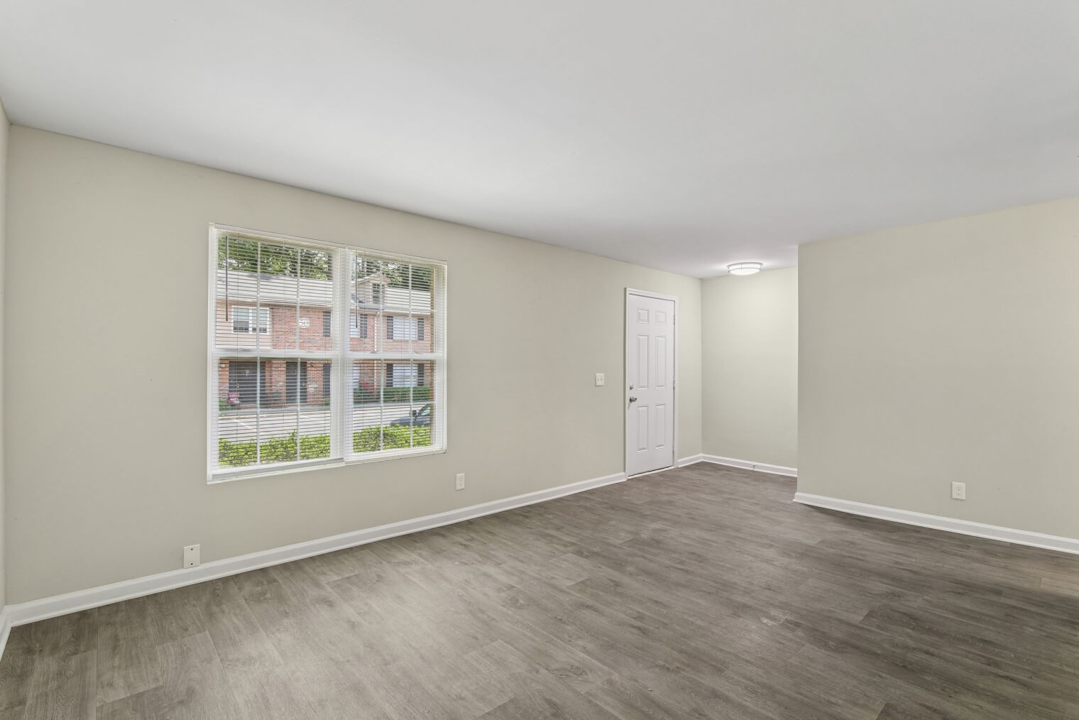 Modern living room at Flourish Park apartments in Clarkston, GA, featuring open-concept layout and hardwood-style flooring.